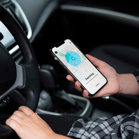 Professional hand holding smartphone displaying Skipcart delivery app with map interface showing blue search radius and "Searching" status, demonstrating SirCharles.DESIGN's intuitive driver-first mobile UX design that powered 7-Eleven's $65M strategic acquisition