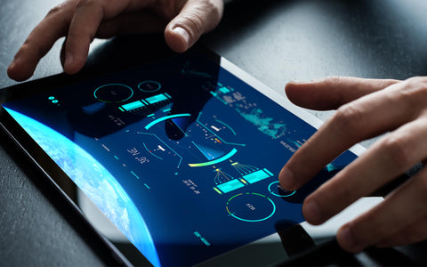 Hands interacting with HIVE interface on tablet showing real-time satellite anomaly detection and circular data displays, illustrating SirCharles.DESIGN's AI-powered system reducing critical event response times from minutes to seconds