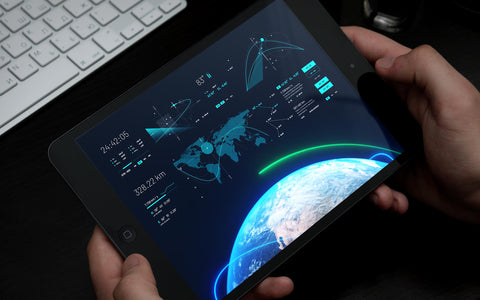 Hands operating tablet displaying HIVE unified mission command interface with Earth view, satellite tracking, and orbital mechanics data, showcasing SirCharles.DESIGN's breakthrough single-operator multi-satellite management system